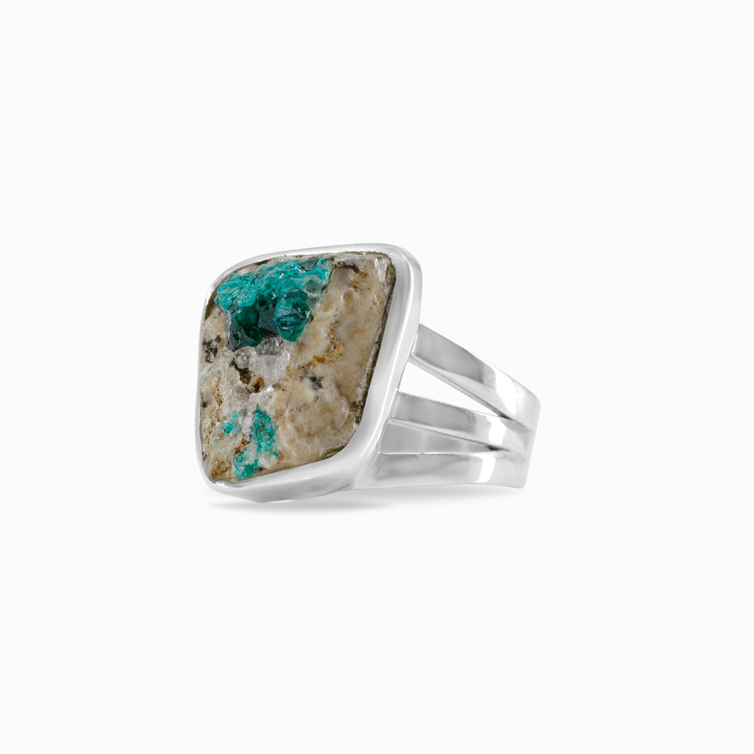 Silver ring with a rough freeform green gemstone on a white background