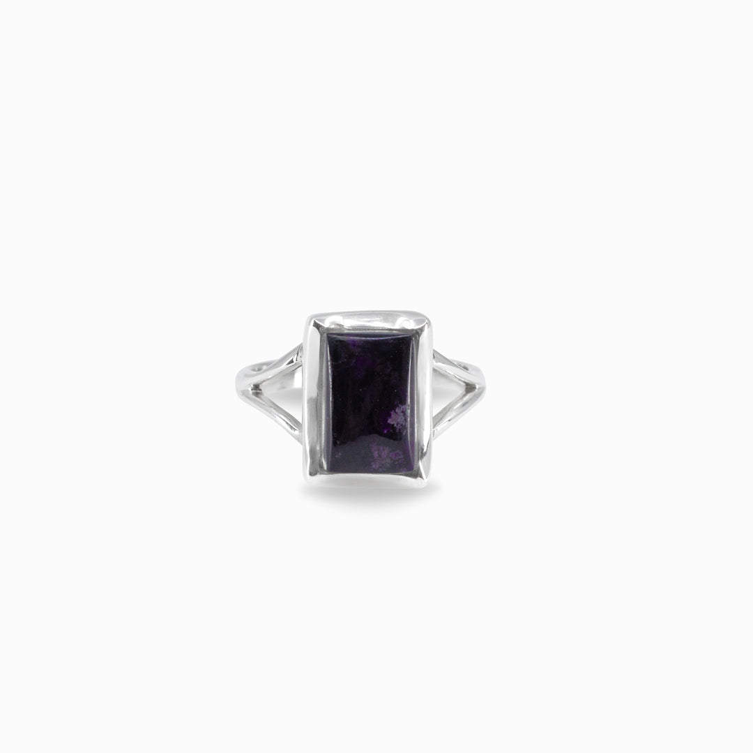 Silver ring with a rectangular purple gemstone on a white background