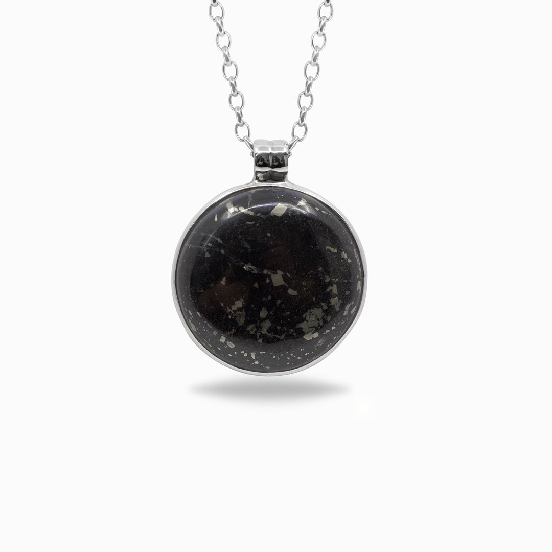 Black stone pendant on a silver chain against a white background