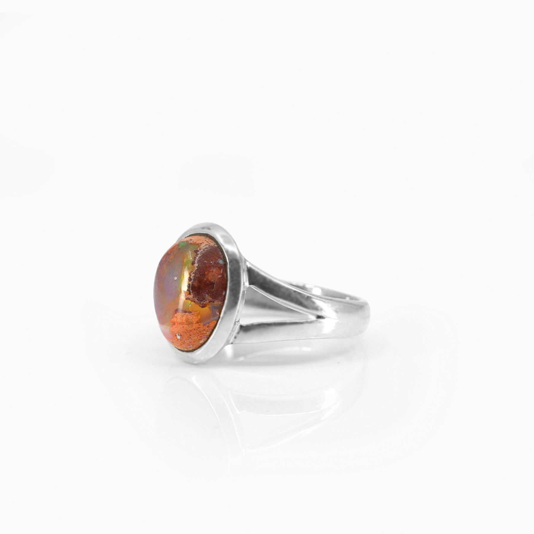 Silver ring with an oval opal stone on a white background