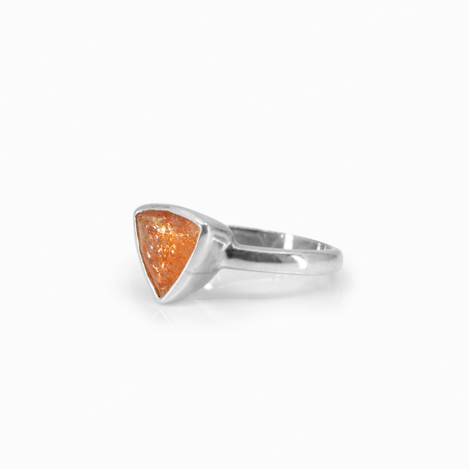 Silver ring with a triangular orange stone on a white background