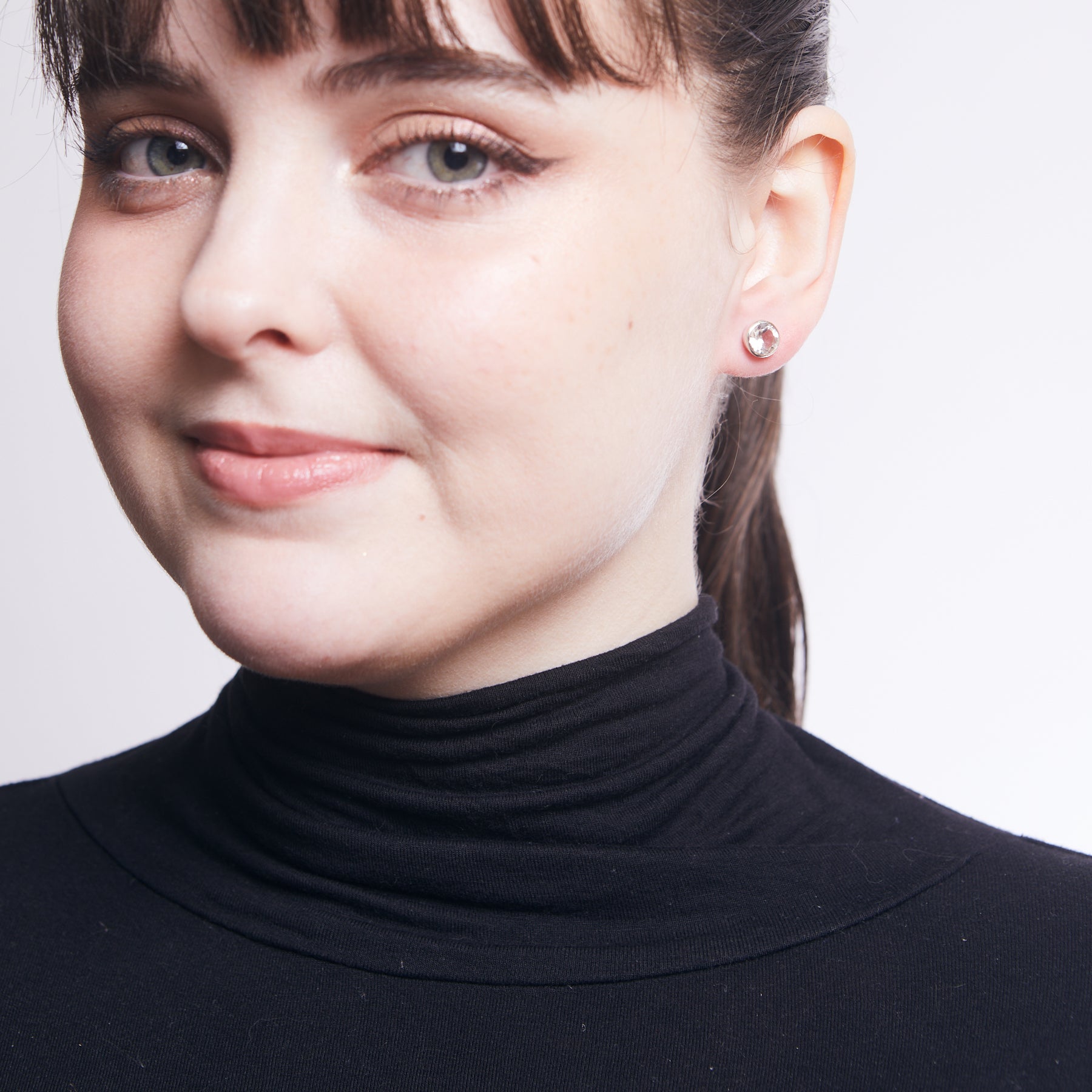 Clear Quartz faceted round bezel set stud earrings on model