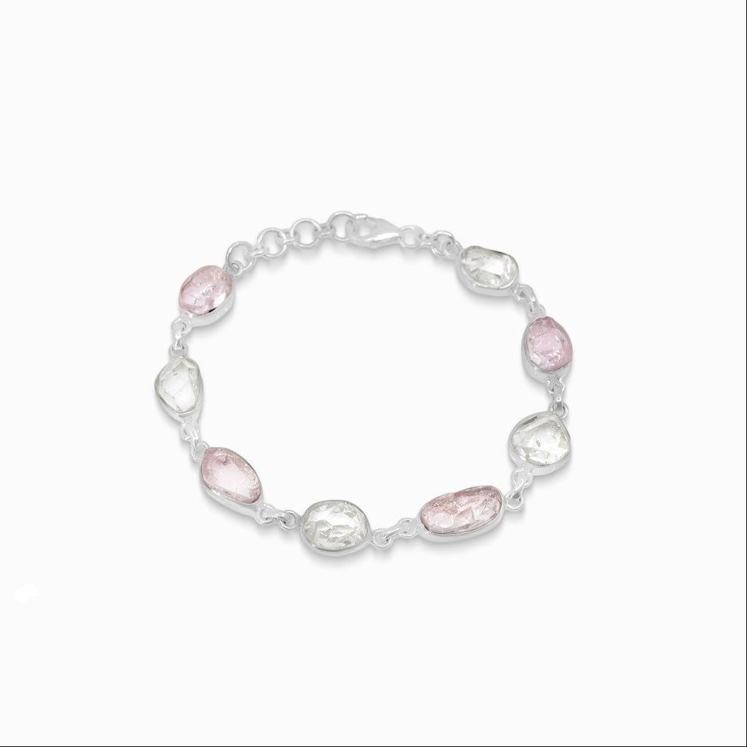Silver bracelet with pink and clear gemstones on a white background
