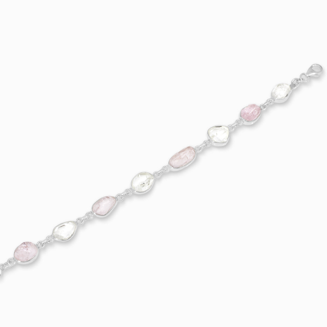 Silver bracelet with pink and clear gemstones on a white background