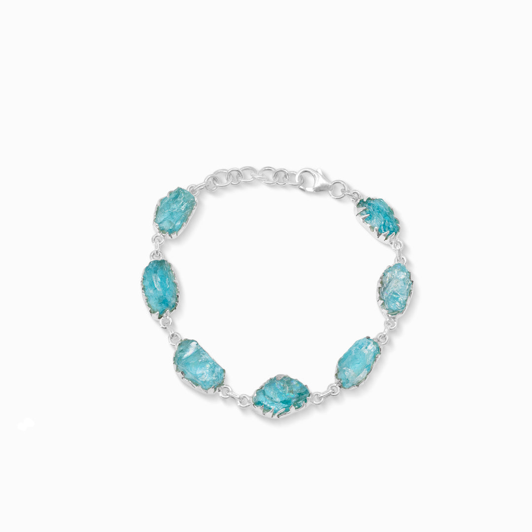 Silver bracelet with light blue rough stones on a white background