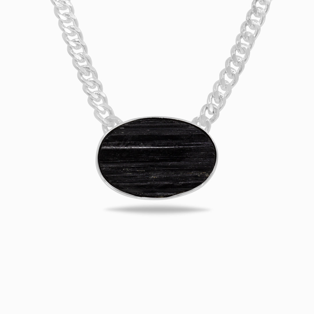 Silver necklace with a black gemstone on a white background