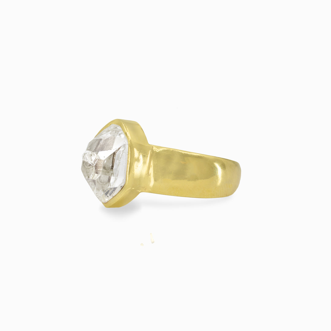 Gold ring with a clear stone on a white background