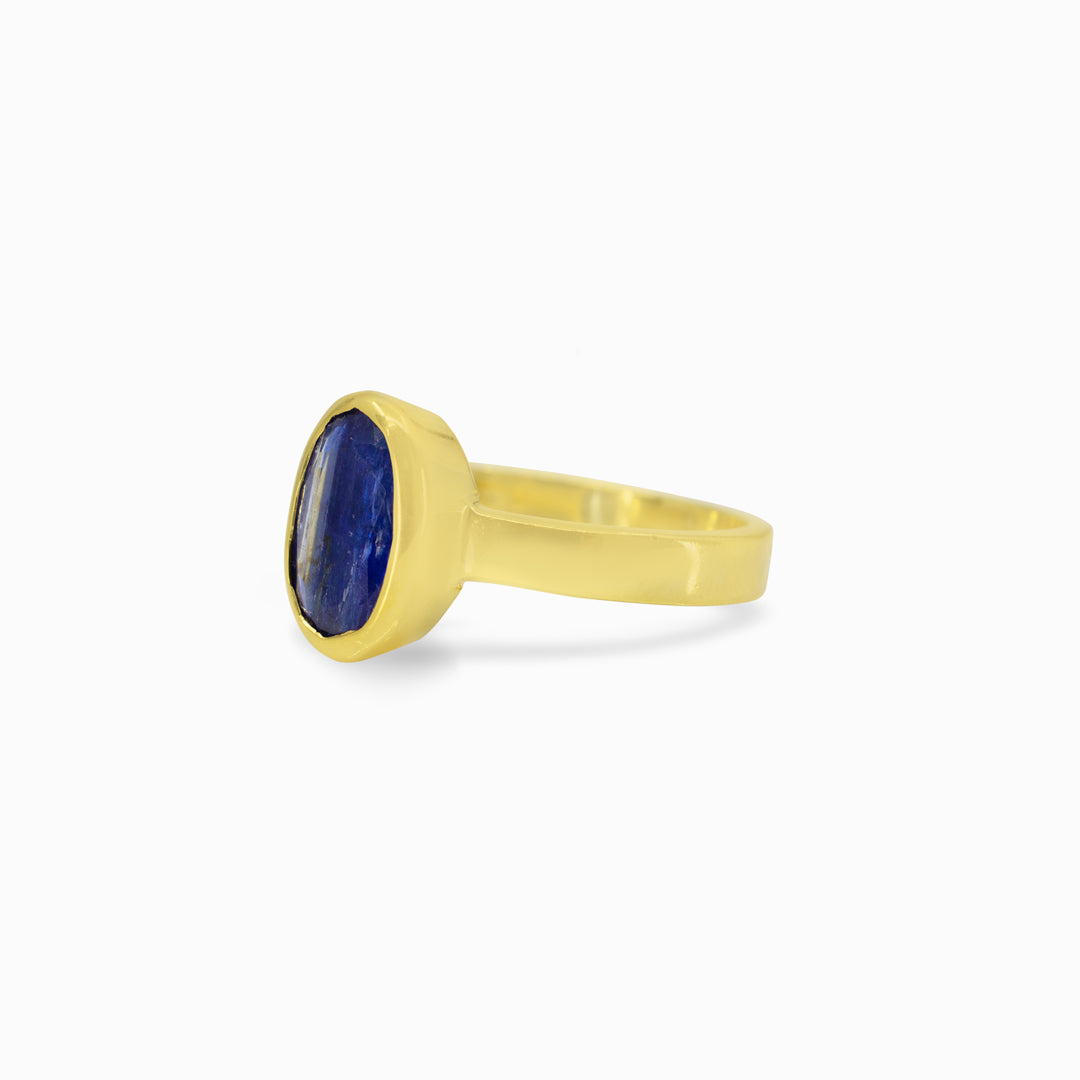 Gold ring with a blue gemstone on a white background