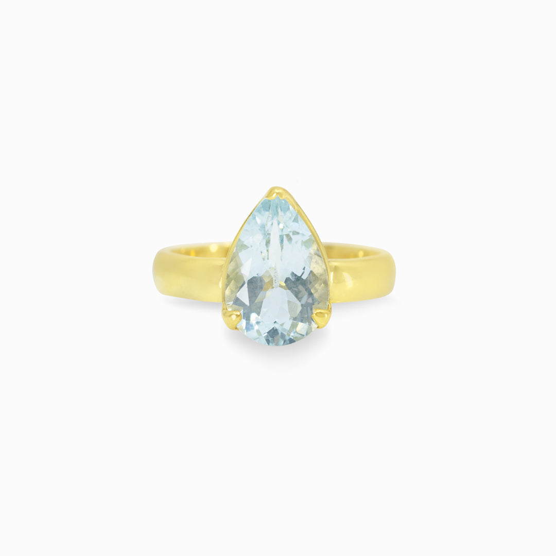 Gold ring with a light blue gemstone on a white background