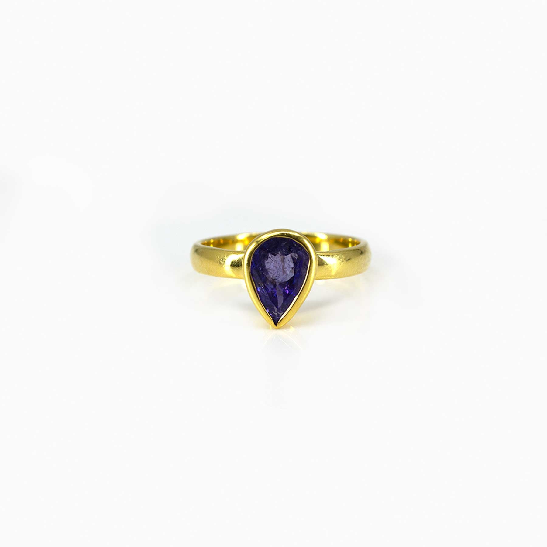 Gold ring with a blue gemstone on a white background