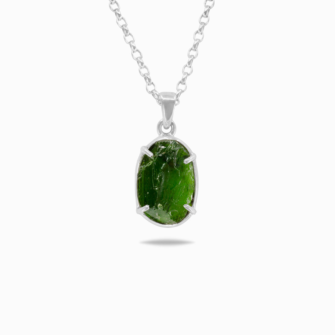 Silver necklace with a green gemstone on a white background