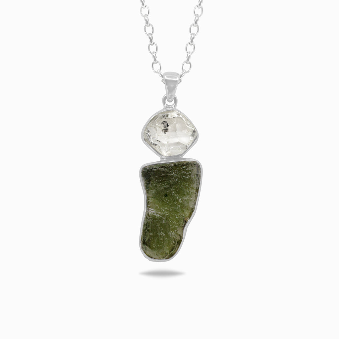 Silver necklace with a clear and a green gemstones on a white background