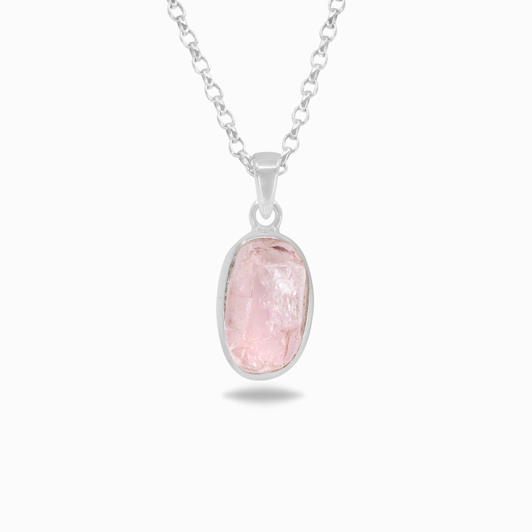 Silver necklace with a pink gemstone on a white background