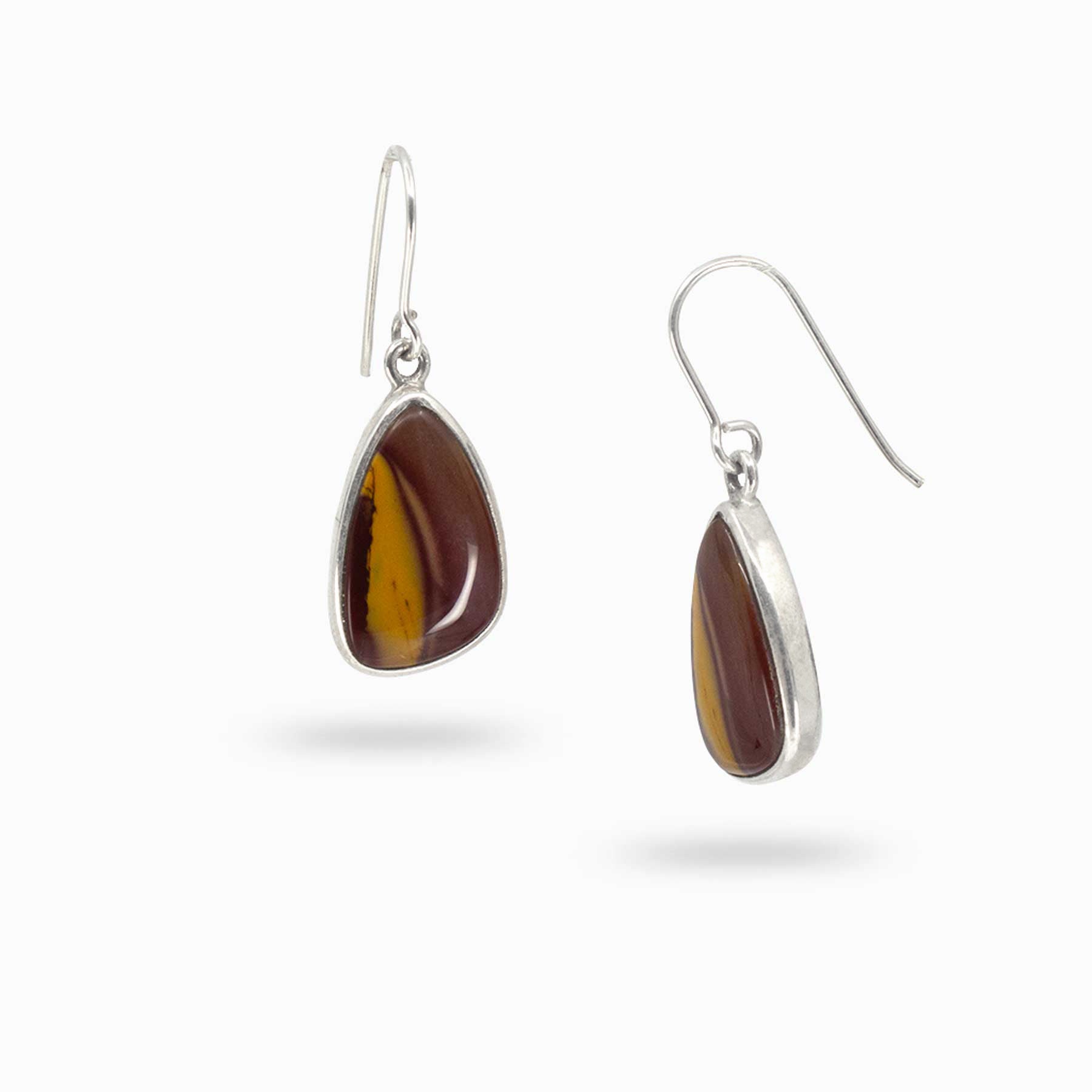 Pair of silver drop earrings with red and yellow gemstones on a white background