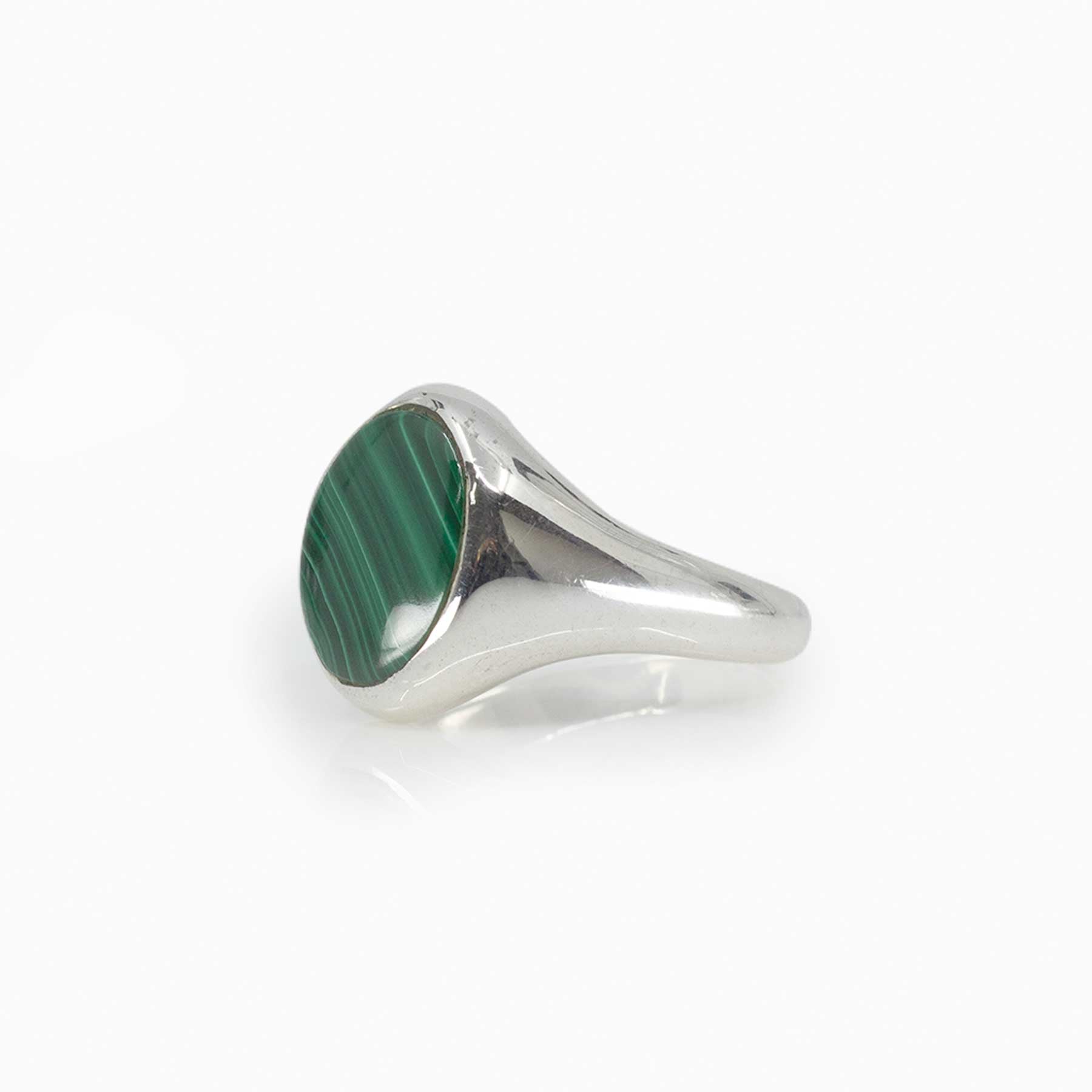 Silver ring with a green stone on a white background