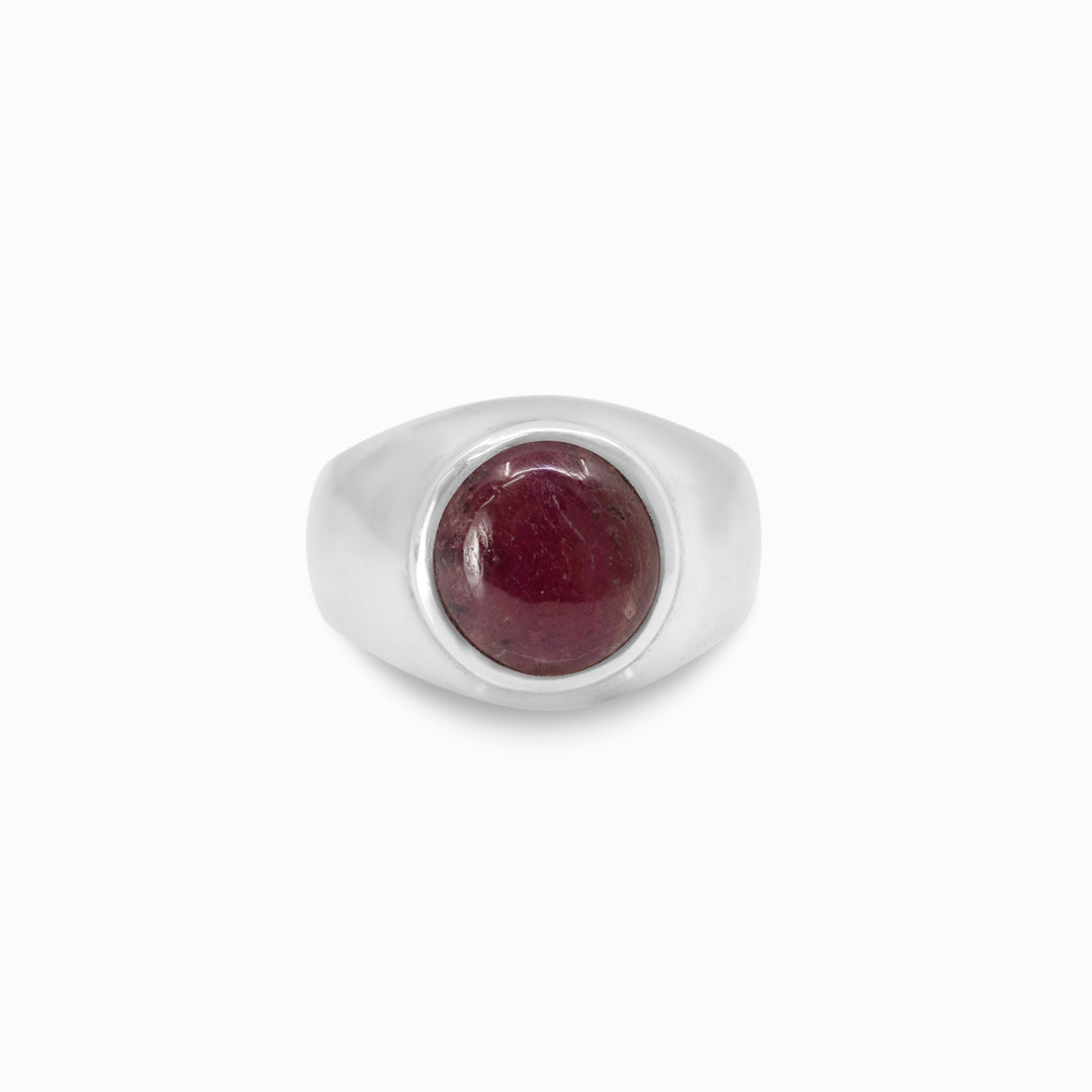 Silver ring with a red gemstone on a white background