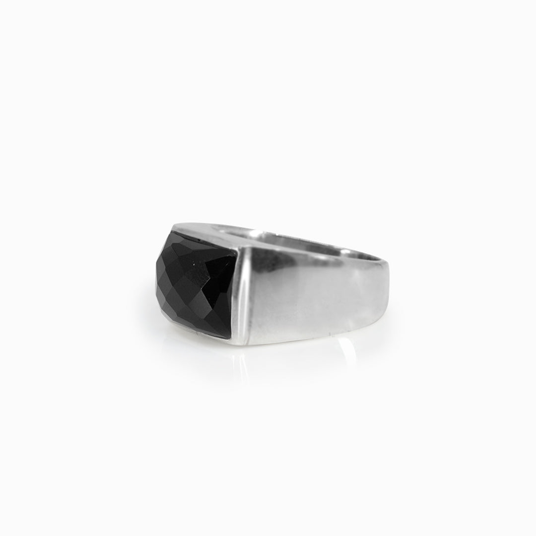 Silver ring with a black gemstone on a white background