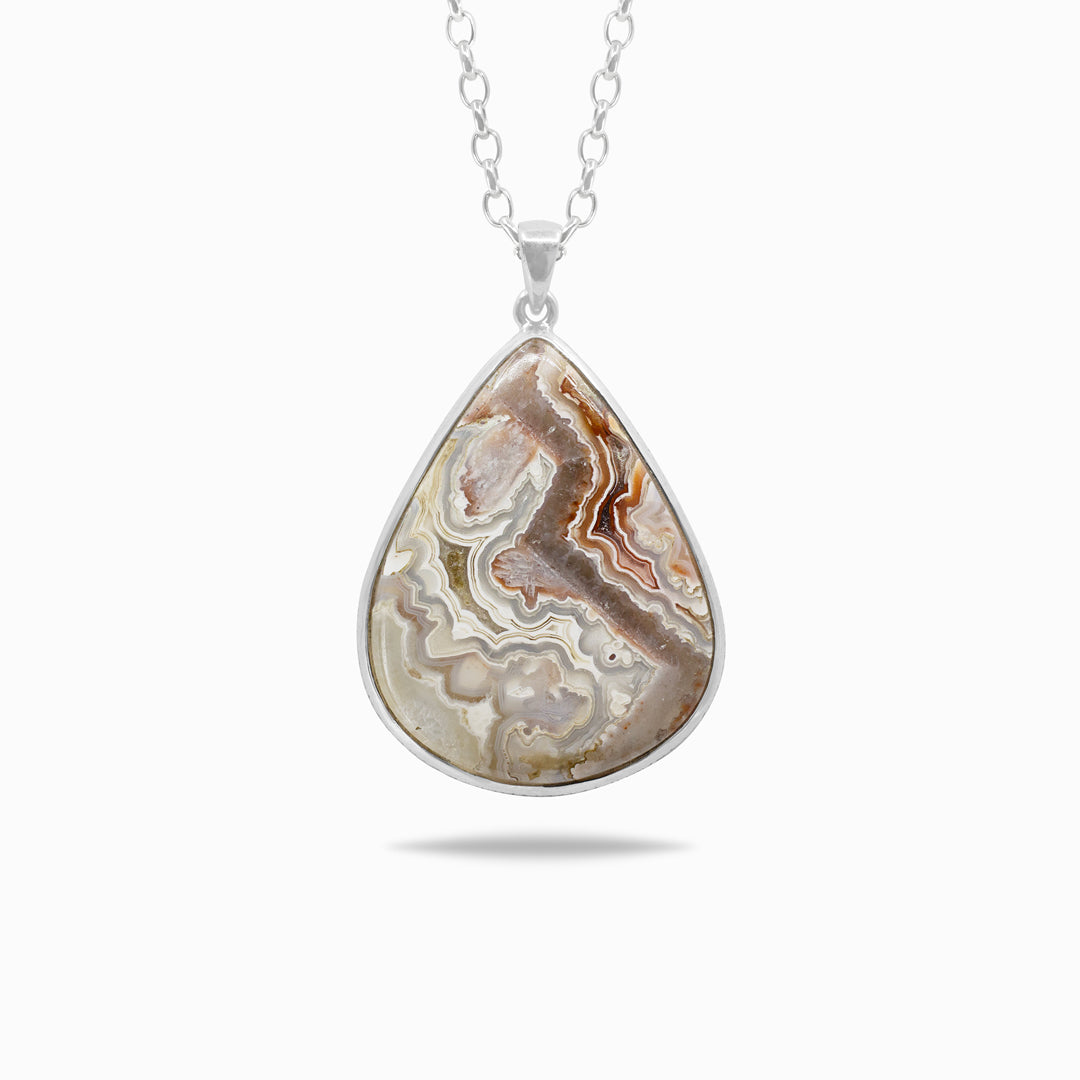 Teardrop-shaped silver pendant with a patterned stone on a white background