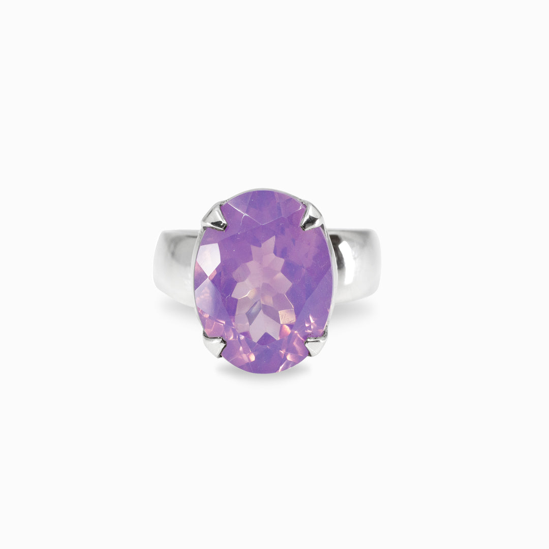 Silver ring with a purple gemstone on a white background