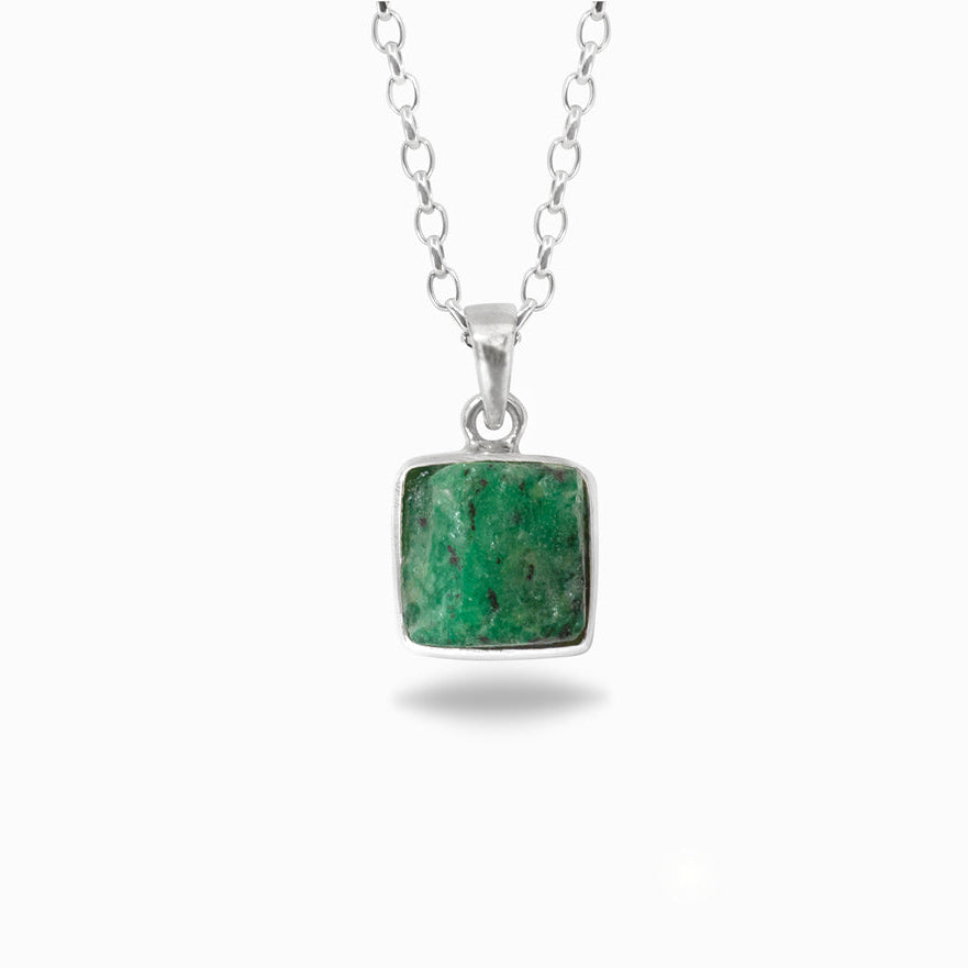 Green stone pendant on a silver chain against a white background