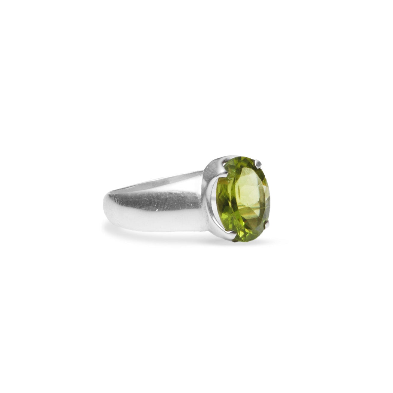 Peridot oval faceted ring with claw setting and thick a-line band