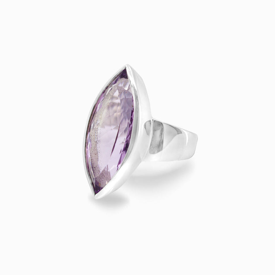 Silver ring with a marquise-shaped purple gemstone on a white background