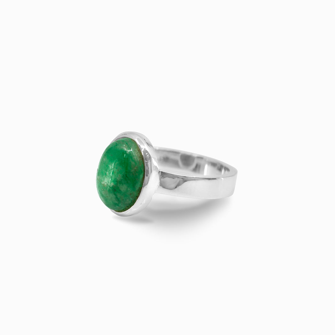 Silver ring with a green stone on a white background