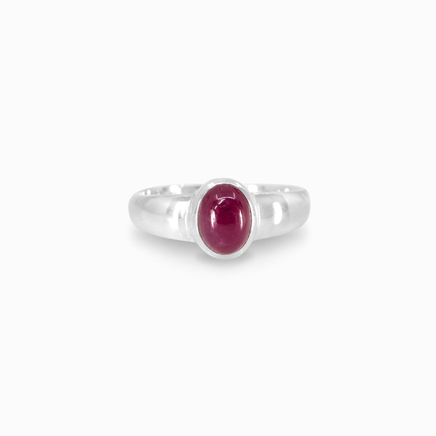 Silver ring with a red gemstone on a white background