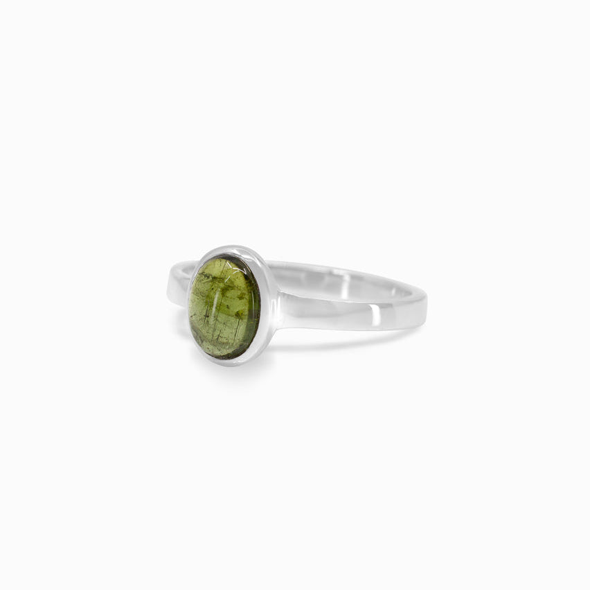 Silver ring with a green gemstone on a white background