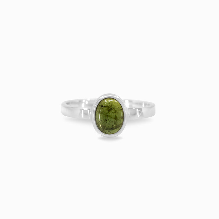 Silver ring with a green gemstone on a white background