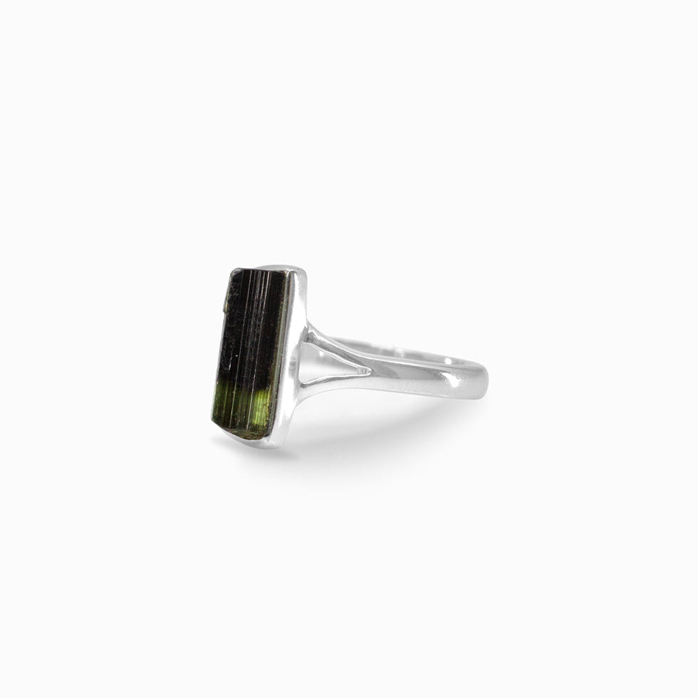 Silver ring with a green stone on a white background
