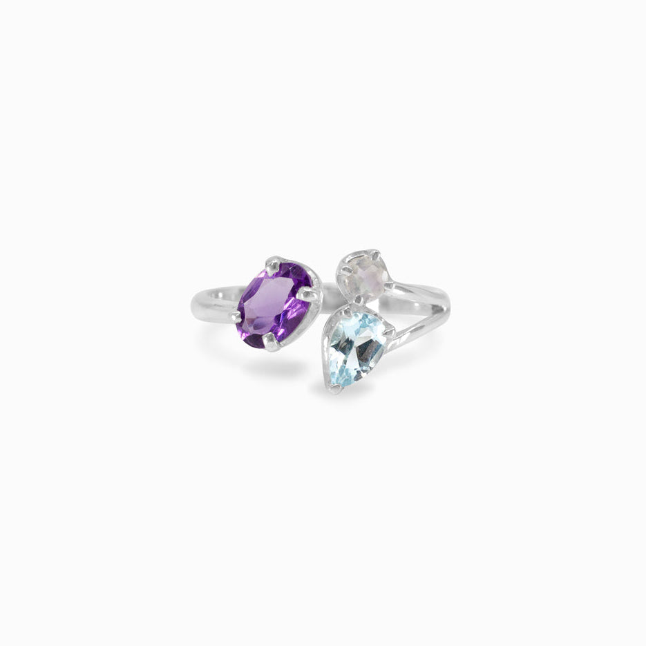 Silver ring with purple, blue and clear gemstones on a white background