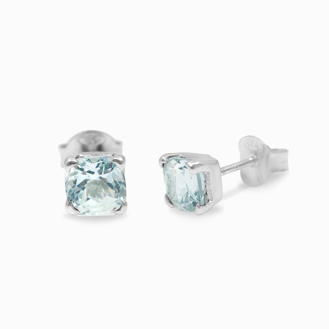 Pair of silver stud earrings with blue gemstones on a white background