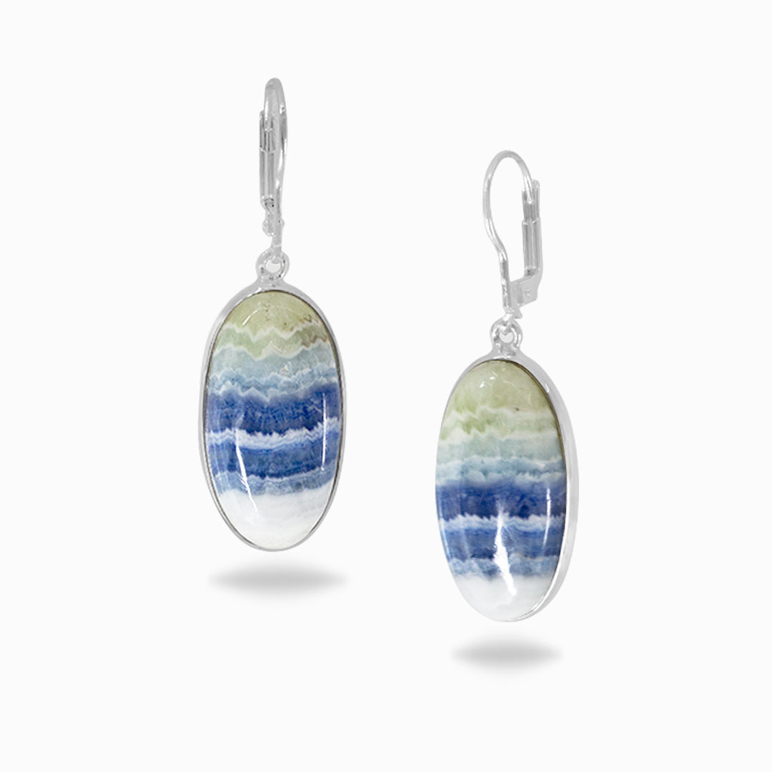 Oval-shaped silver earrings with blue and white striped stones on a white background