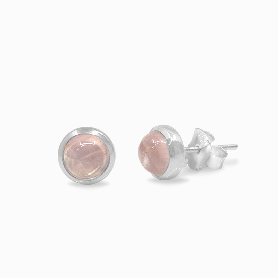Pair of silver earrings with pink gemstones on a white background