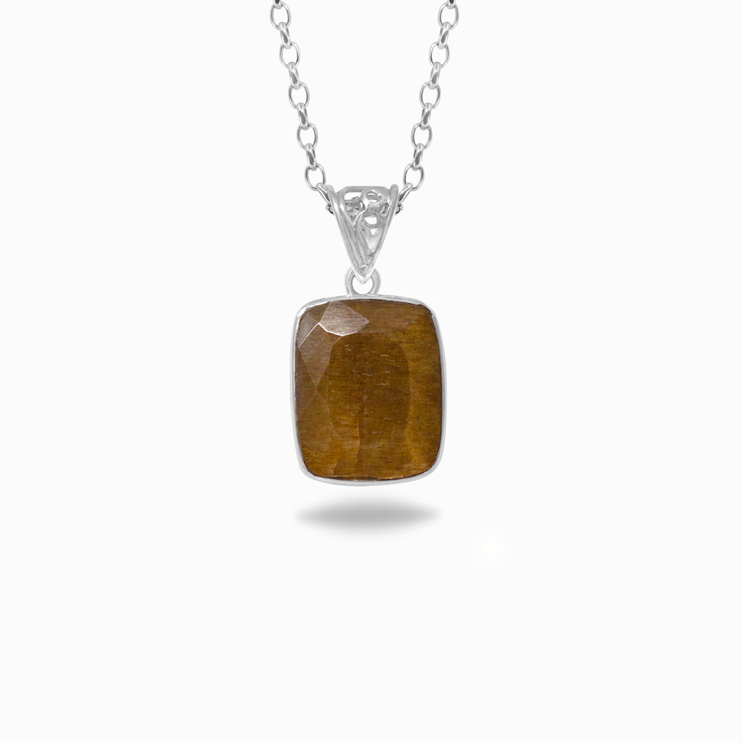 Golden pendant on a silver chain against a white background