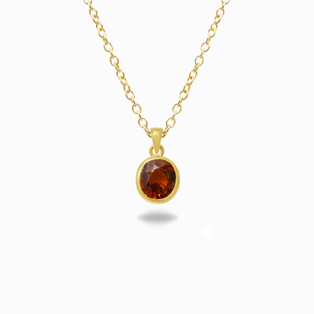 Gold necklace with an oval orange gemstone pendant on a white background