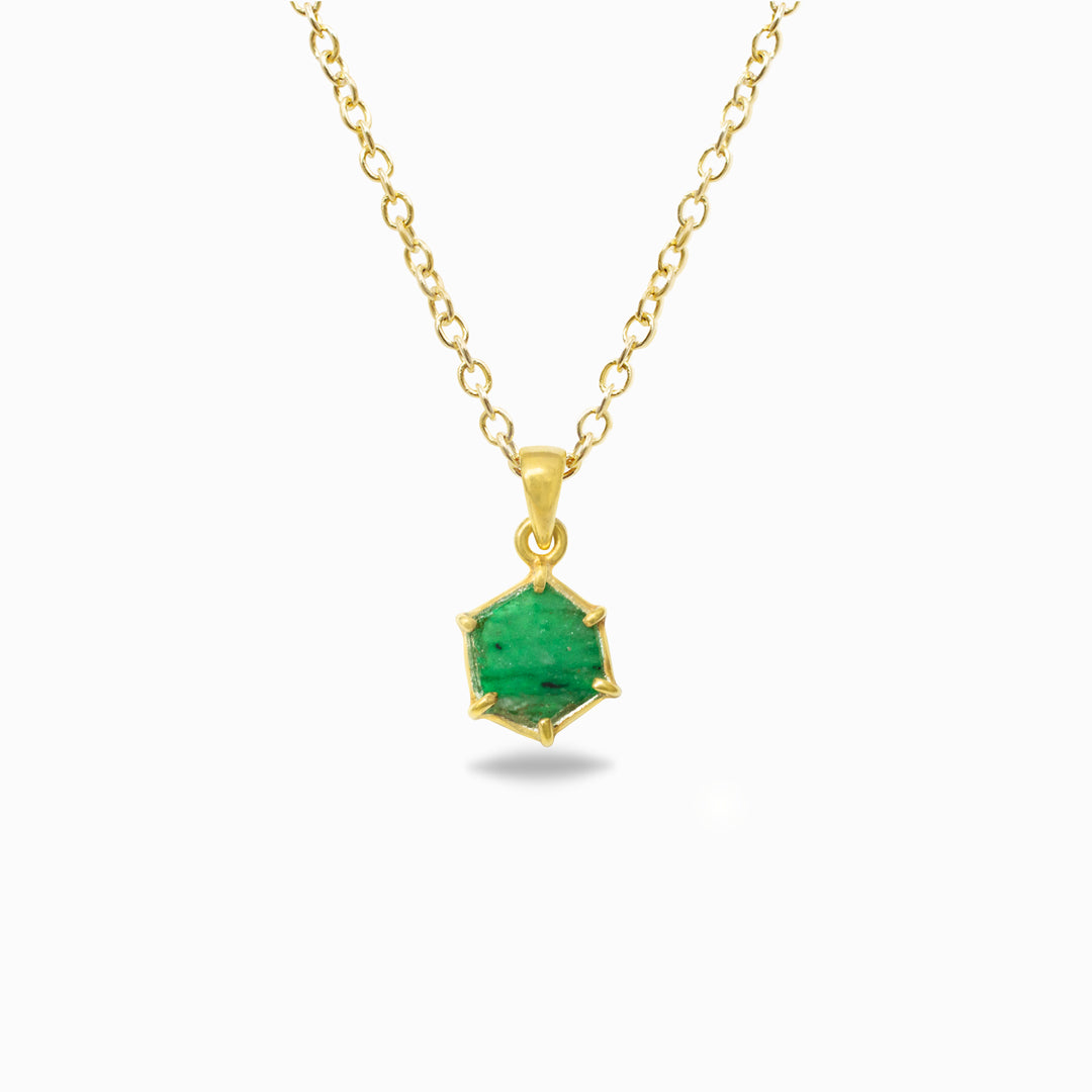 Gold necklace with a green gemstone pendant on a white background