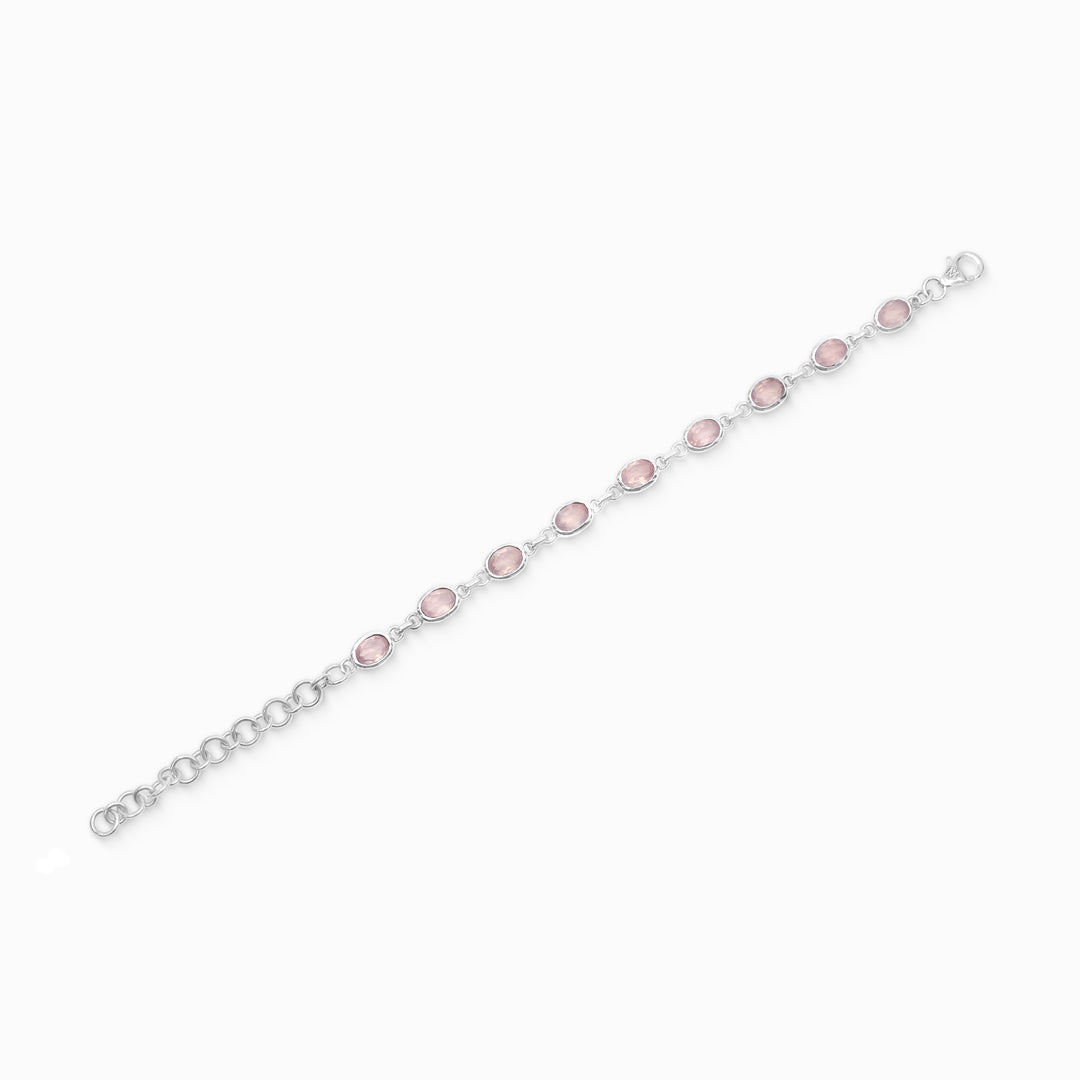 Silver bracelet with pink gemstone on a white background