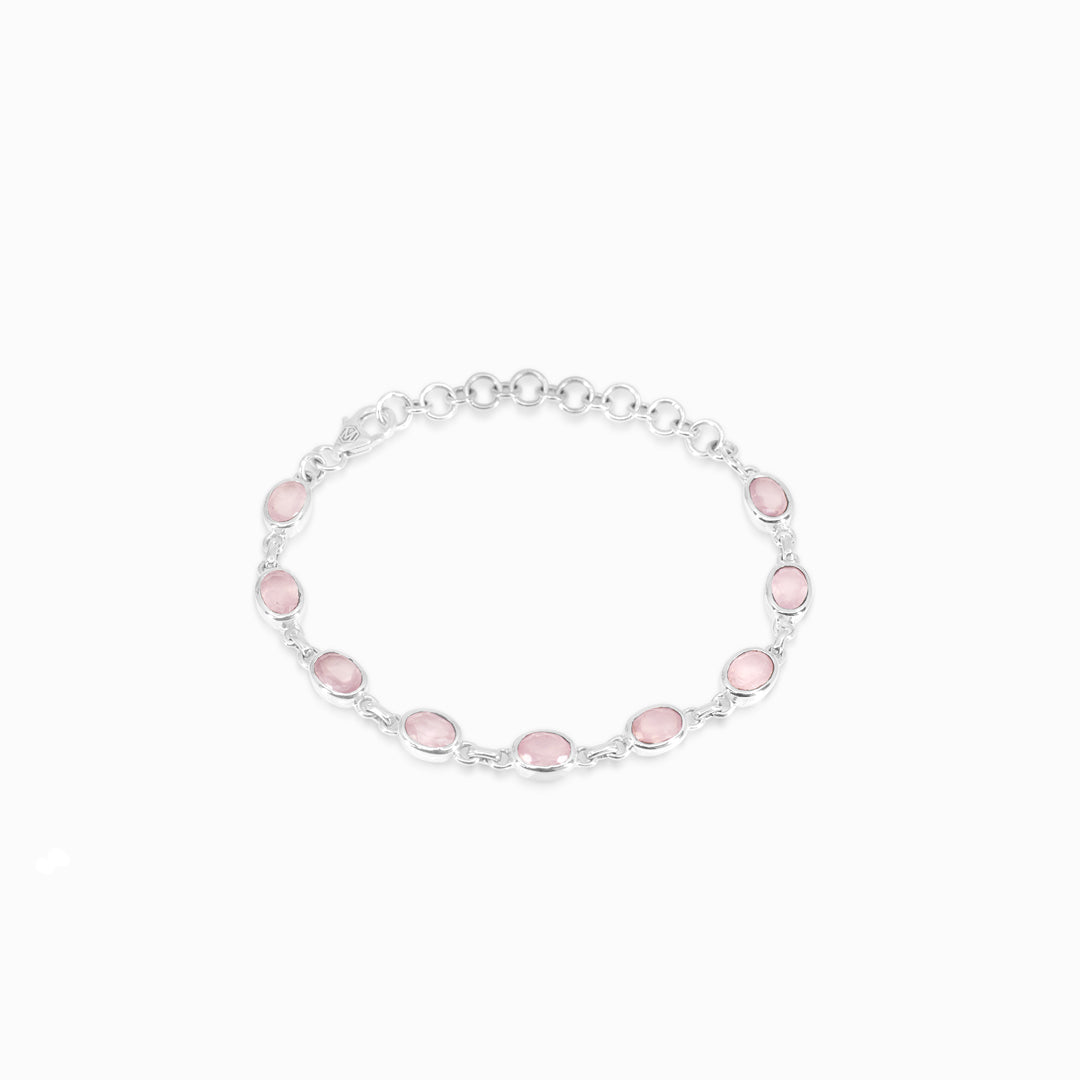 Silver bracelet with pink gemstone on a white background