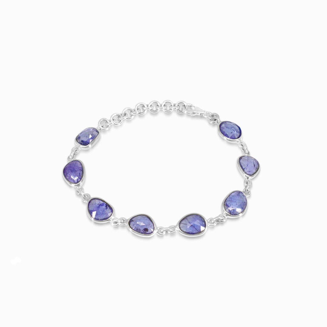 Silver bracelet with blue gemstones on a white background