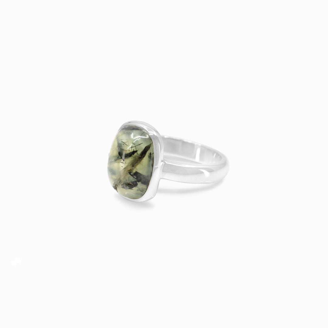 Silver ring with a green gemstone on a white background
