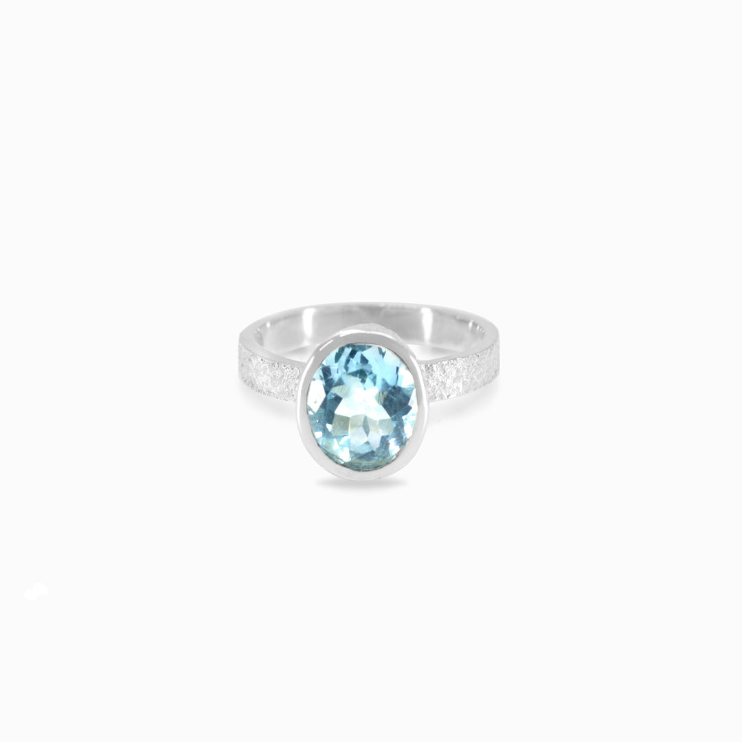 Silver ring with a blue gemstone on a white background