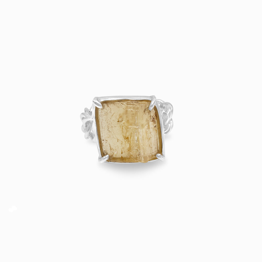 Silver ring with a yellow stone on a white background