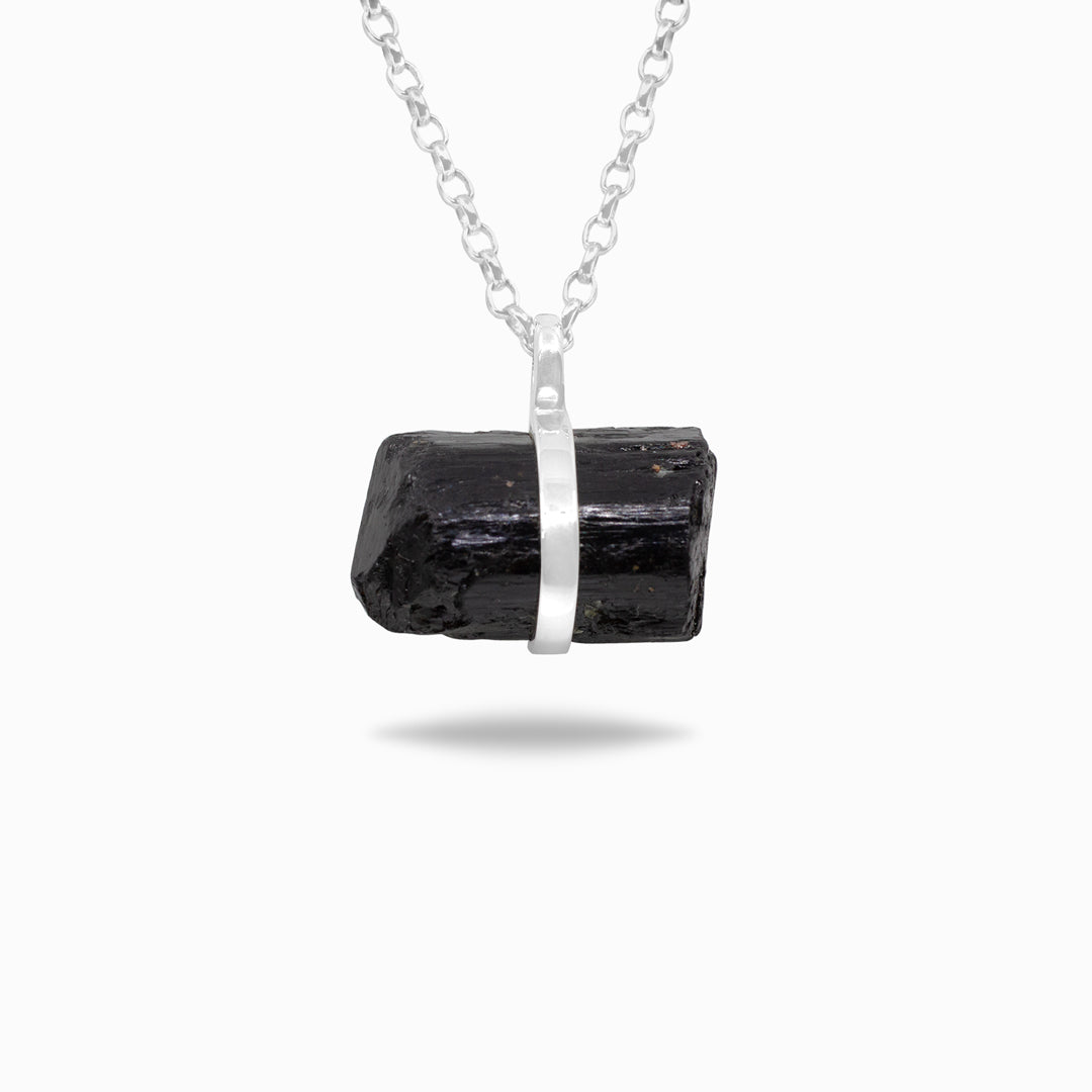 Silver necklace with a black gemstone on a white background