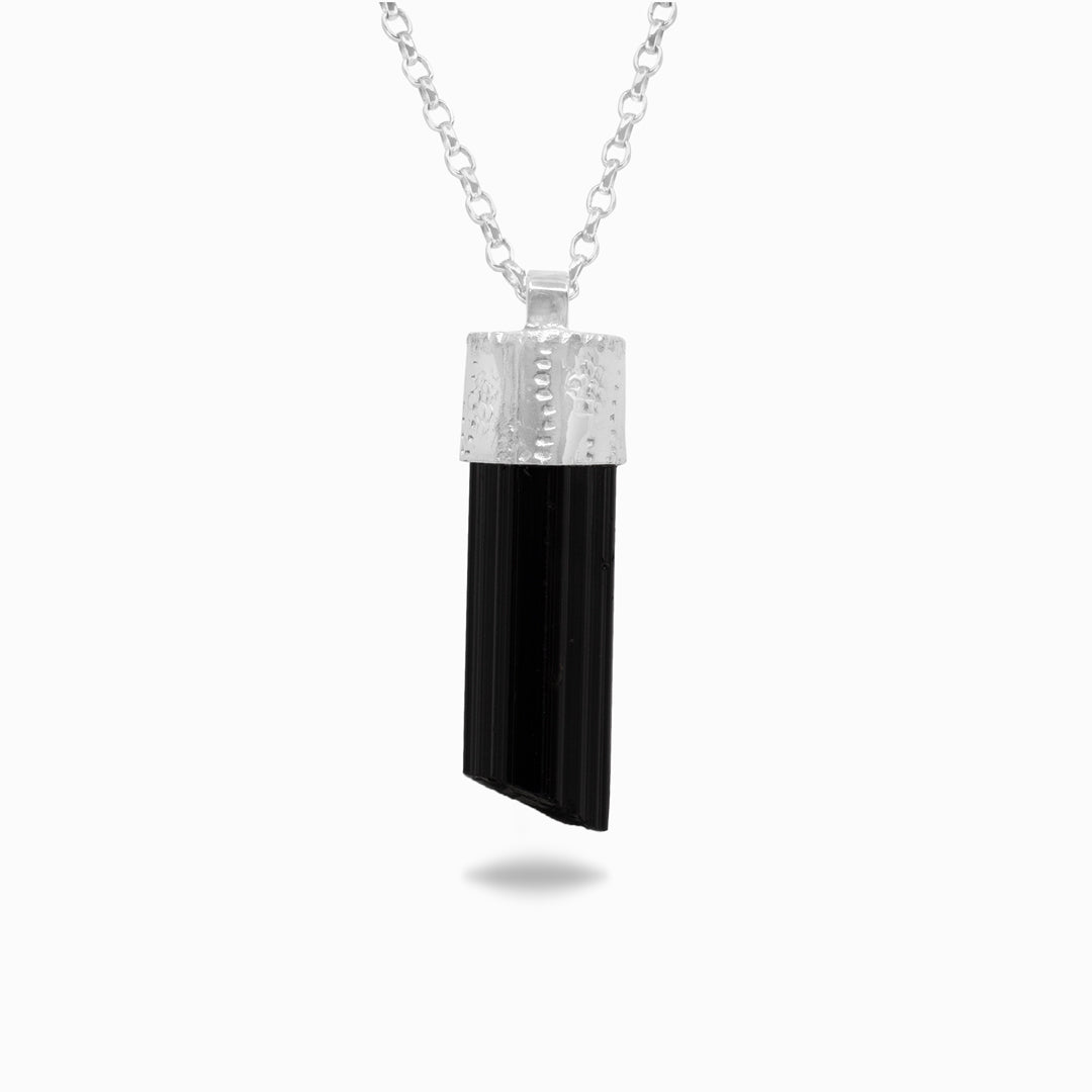 Silver necklace with a black stone on a white background
