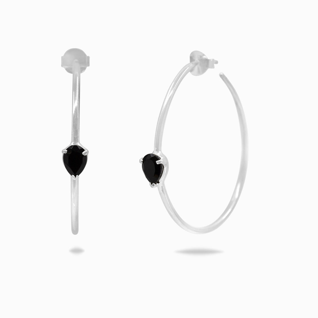 Silver hoop earrings with black stones on a white background