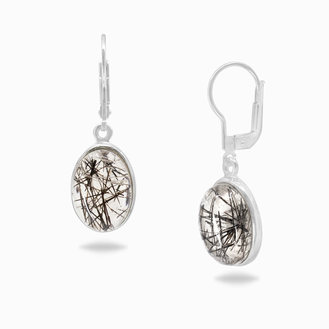 Silver earrings with clear and black stone on a white background