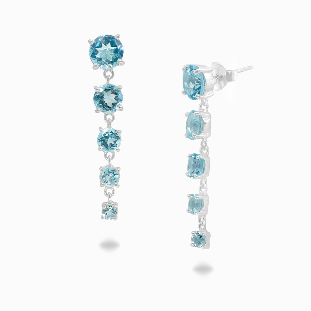 Pair of silver earrings with 5 blue gemstones on a white background