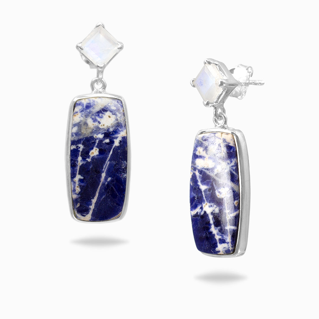 Pair of silver earrings with blue and white stones on a white background